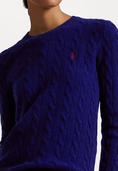Suéter azul de malha com textura, feito de lã, com gola redonda e um pequeno logótipo vermelho no lado esquerdo do peito.