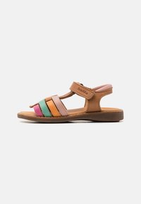 Sándalo de cuero marrón con tira de velcro, que presenta rayas horizontales en colores pastel en rosa, verde, naranja y púrpura. Suela plana de goma.