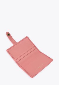 Porte-cartes en cuir rose ouvert avec deux fentes pour cartes et bandeau à bouton-pression, "Kurt Geiger London" embossé en lettres dorées.