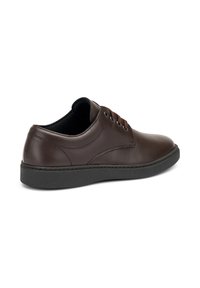 Scarpa in pelle marrone con una finitura liscia, punta tonda, cinque asole e suola in gomma nera. Presenta cuciture sottili e un design a profilo basso.