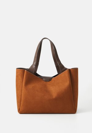Brown suede tote bag with dark leather handles, featuring a structured shape and contrasting stitching. Includes a subtle brand logo on the front.