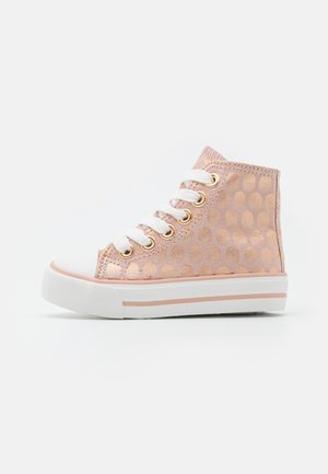 Baskets montantes pour enfants avec des pois dorés rose, lacets blancs, œillets dorés, bout blanc et semelle en caoutchouc blanche avec des rayures rose clair.
