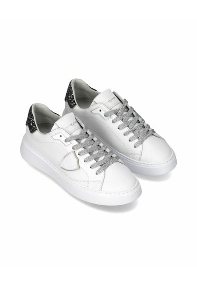 Witte lage sneakers met zilverkleurige glinsterende veters en zwarte glitterhielstukjes, naast elkaar getoond op een witte achtergrond.