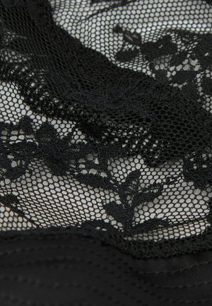 Schwarzer Spitzenstoff mit floralen Mustern, der über einem feinen Netzgewebe liegt, und dabei Textur sowie filigrane Details zeigt.