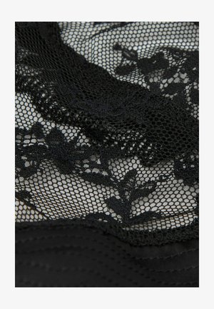 Schwarzer Spitzenstoff mit floralen Mustern, der über einem feinen Netzgewebe liegt, und dabei Textur sowie filigrane Details zeigt.