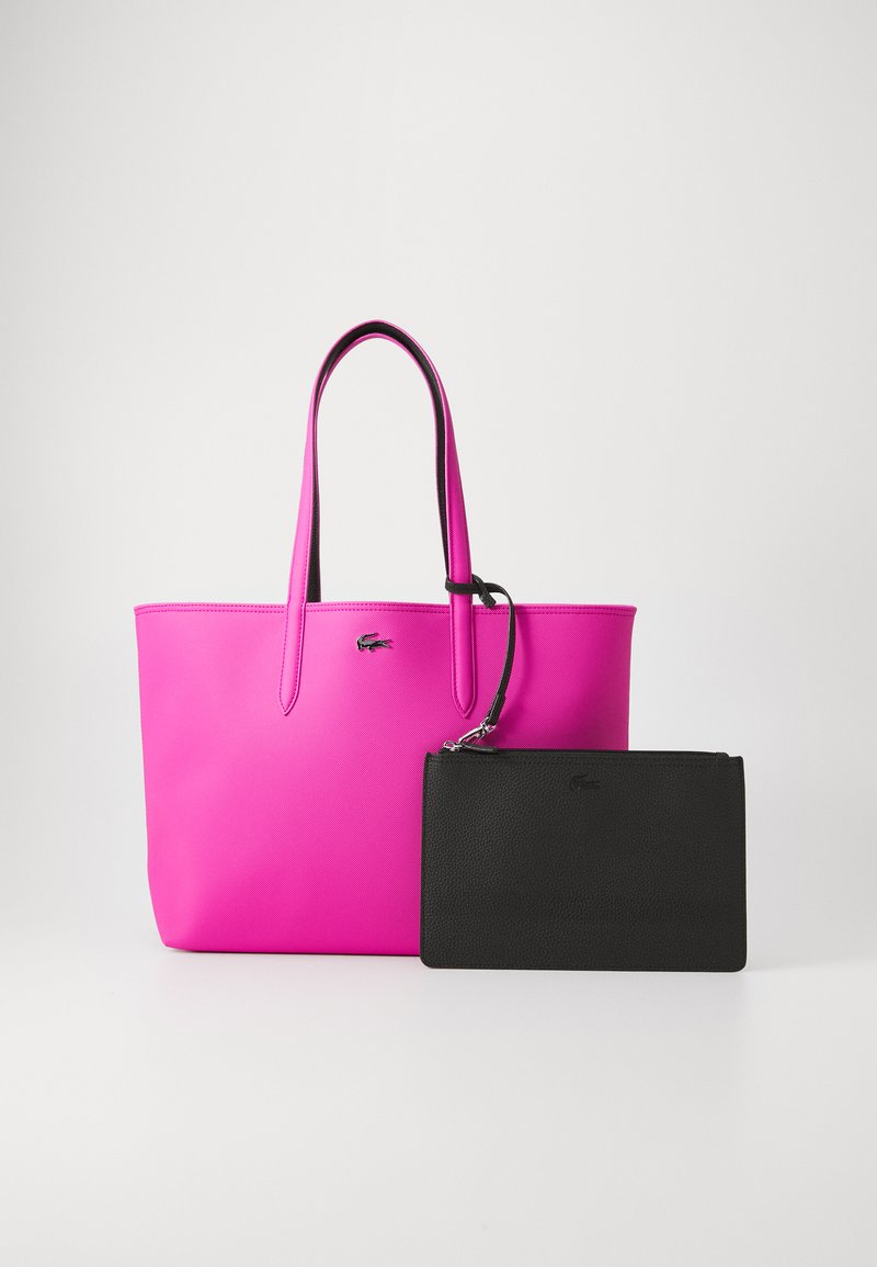 Roze synthetische tote bag met lange handvatten, gecombineerd met een kleine zwarte etui met tekstuur, voorzien van een rits en logo-detail.
