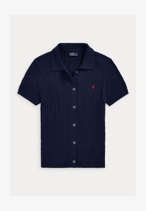 Cardigan bleu marin cu mâneci scurte, textură tricotată cu model împletit, nasturi în față, guler și un mic logo roșu brodat pe pieptul stâng.