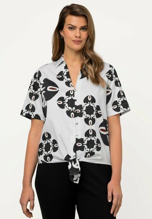 Blusa a maniche corte in tessuto grigio chiaro con un audace motivo astratto in bianco e nero e dettagli rossi, legata in vita per una vestibilità rilassata.
