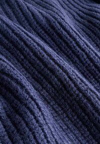 Marineblå strikket stof med hævede vandrette ribber, der viser et struktureret udseende og en blød, fuzzy finish.