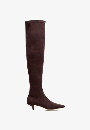 Bota de ante marrón oscuro hasta la rodilla, con punta afilada y tacón bajo tipo kitten. Textura lisa y diseño sin adornos.