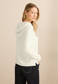 Witte hoodie met een trekkoord, lange mouwen, zijsplitten aan de zoom en een relaxte pasvorm. Draag het met donkere jeans voor een casual uitstraling.