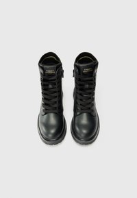 Sorte skinn snørestøvler med høy ankel design, prydet med gulllogo og robuste gummisåler for holdbarhet.