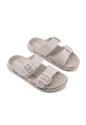 Sandali beige slip-on con due cinturini regolabili con fibbia e suole strutturate, etichettati "holster" nella soletta.