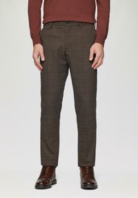 Bruine geruite pantalon gemaakt van stof, met een getailleerde pasvorm, zijzakken en een gladde afwerking, gecombineerd met bruine leren veterschoenen.