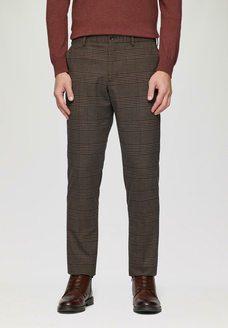 Bruine geruite pantalon gemaakt van stof, met een getailleerde pasvorm, zijzakken en een gladde afwerking, gecombineerd met bruine leren veterschoenen.