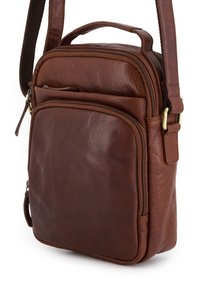 Hnědá kožená crossbody taška s předními a horními zipovými přihrádkami a nastavitelním popruhem se zlatým kováním.