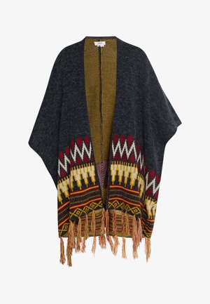 Grijze gebreide poncho met een gele gemusterde binnenkant, tribale motieven in rood, wit en geel, en franjes aan de onderkant.