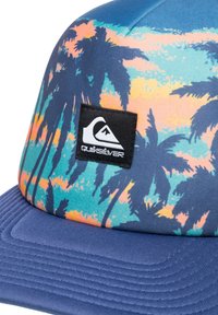 Kšiltovka s modrým texturovaným kšiltem a barevným vzorem palmových stromů na vršku. Obsahuje černou nášivku s logem Quiksilver.