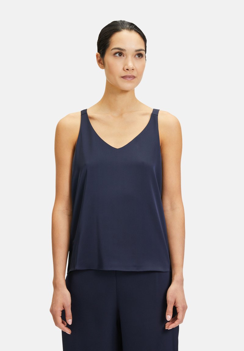 Granatowa satynowa cami z dekoltem w literę V, cienkimi ramiączkami, luźnym krojem i gładką fakturą. Idealna do noszenia na warstwy lub w codziennych stylizacjach.