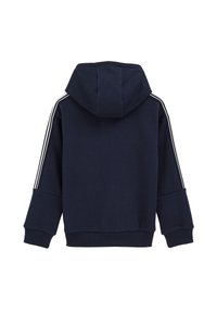 Tumši zila kapuce ar baltām sānu svītrām uz piedurknēm, elastīgām aprocēm un apakšu. Mīksts audums ar vaļīgu piegriezumu, aprīkots ar kengūra kabatu.