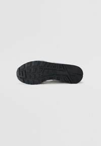 Black rubber outsole with textured patterns. Features a white midsole with gray and blue accents. Designed for traction and support.