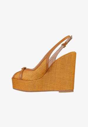 Sandalo con zeppa intrecciato marrone con punta aperta, cinturino alla caviglia e dettaglio di fibbia dorata su sfondo bianco.