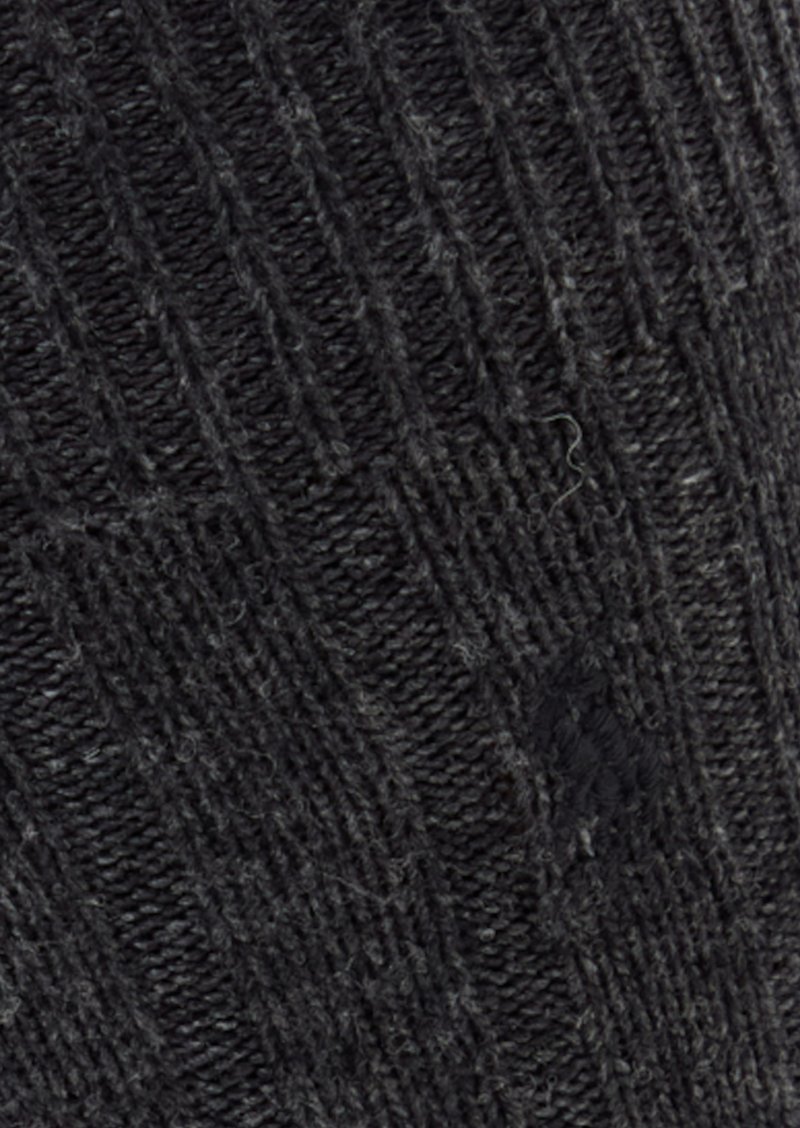 Calzino nero lavorato a maglia con una texture a coste, caratterizzato da un motivo diagonale e sottili variazioni di tonalità. Realizzato in materiale morbido e caldo.