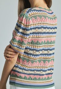 Multikleurige gebreide trui met korte mouwen, intricate patronen van pink, groen, blauw en beige, met een geribbelde zoom en een gestructureerd ontwerp.