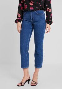 Höga blå denimbyxor med rak passform, med knappstängning fram, bälteshällor och minimal blekning.