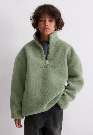 Fleece pullover in zacht, lichtgroen met een hoge kraag en halve ritssluiting. Heeft een ontspannen pasvorm en een geborduurd logo aan de voorkant.