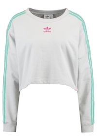 Felpa bianca corta a maniche lunghe, con design a tre strisce turchesi e piccolo logo Adidas rosa sul petto.
