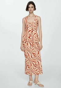 Todelt outfit med en ærmeløs top og en matchende midi-nederdel, begge i et bølget mønster i orange og creme, med en tekstureret finish.