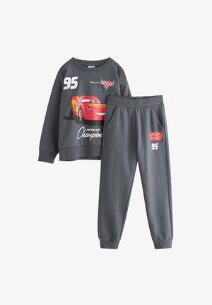 Siva trenirka in hlače z rdečim grafičnim motivom Lightning McQueen, z številko 95 in besedilom "Šampion Piston Cup" v beli barvi.