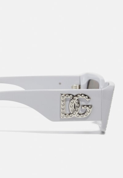 Lunettes de soleil grises avec une finition brillante, dotées d'un logo "DG" argenté rehaussé de clous ronds sur le côté.
