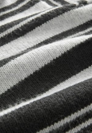 Tessuto a maglia a righe bianche e nere, caratterizzato da una texture morbida con righe a contrasto; visibile peluria e un motivo tessuto.