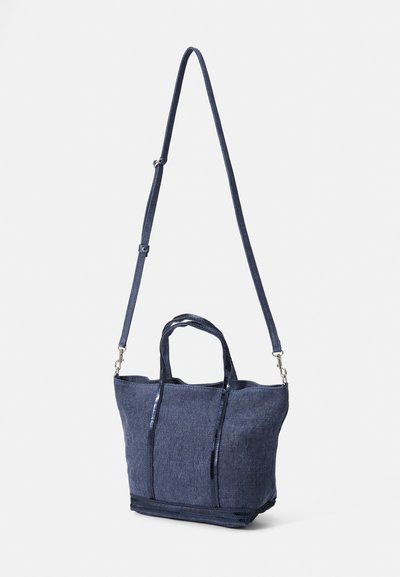 Sac en toile bleu marine avec deux poignées supérieures et une bandoulière détachable ; dispose d'une finition texturée et d'une fermeture éclair en haut.