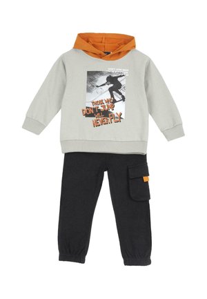 Kinderoutfit mit grauem Hoodie mit Skateboard-Grafik und oranger Kapuze, kombiniert mit schwarzen Hosen mit seitlicher Cargotasche.