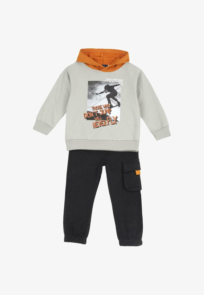 Tenue enfant avec sweat à capuche gris avec un motif skateboard et une capuche orange, associée à un pantalon noir avec une poche cargo latérale.