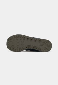Dark blue sneaker with a textured gray rubber sole featuring deep treads and a logo. The upper has a smooth finish and protective accents.