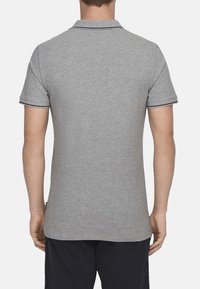 Graues Poloshirt in schmaler Passform; kurze Ärmel, zweiknöpfige Knopfleiste und kontrastierender dunkler Saum an Kragen und Ärmelkanten.