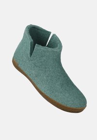 Zielony filcowy botek za kostkę z zaokrąglonym noskiem, otwartą górą i gumową podeszwą. Minimalistyczny design z fakturowaną powierzchnią i bez widocznych elementów metalowych.