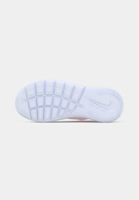 Sneakers Nike Flex z białą gumową podeszwą, posiadające teksturowane wzory antypoślizgowe oraz gładką powierzchnię; różowe akcenty przy śródpodeszwie.