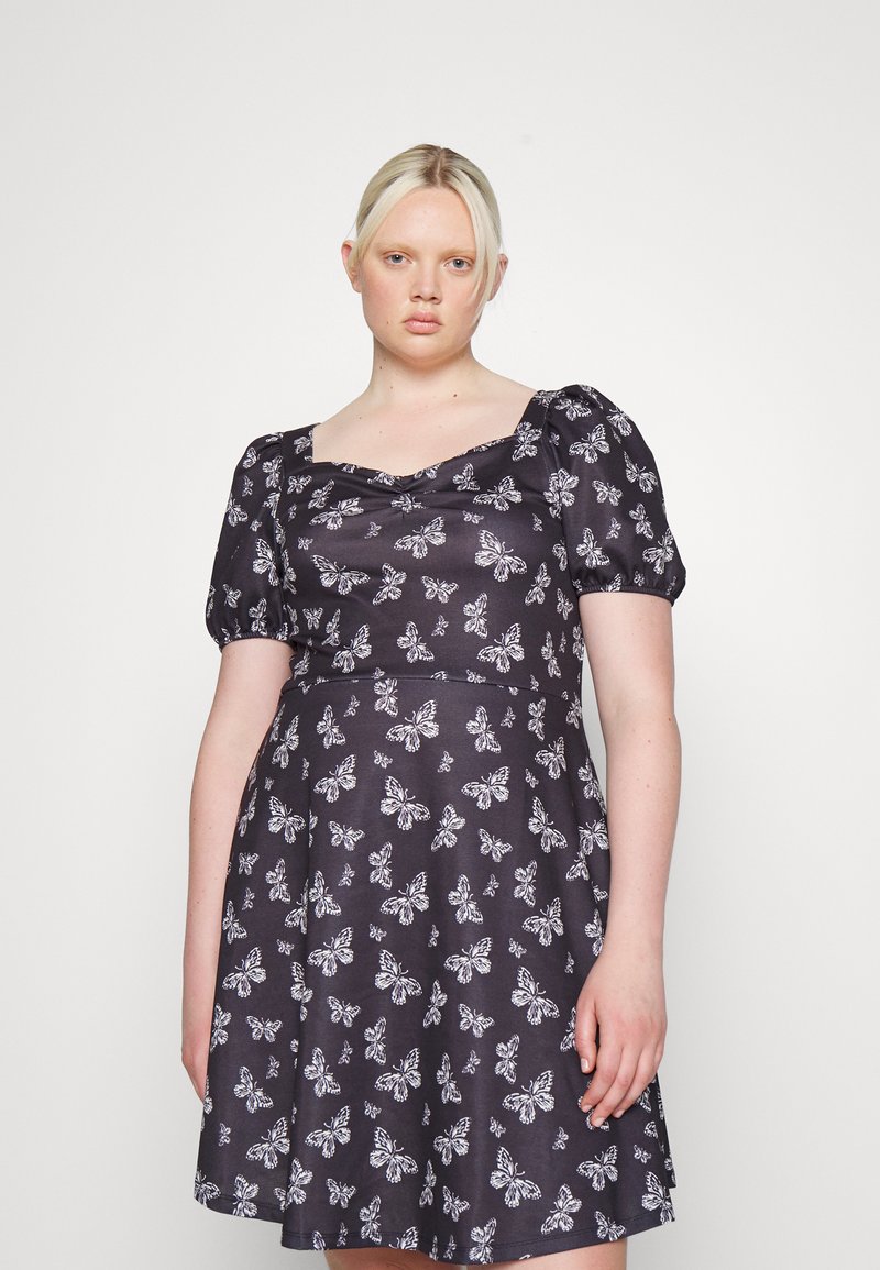 Veste preta com mangas curtas e bufantes, apresentando um padrão de borboletas em branco, decote quadrado e saia fluida. Textura suave.