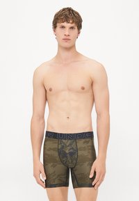 Men's boxer briefs in olive green with a camouflage pattern, featuring a black elastic waistband labeled "AIR UNDER" and a fitted design.