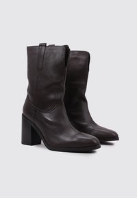 Brown leather ankle boots with a pointed toe, a block heel, and side stitching. Textured upper with pull tabs for easy wear.