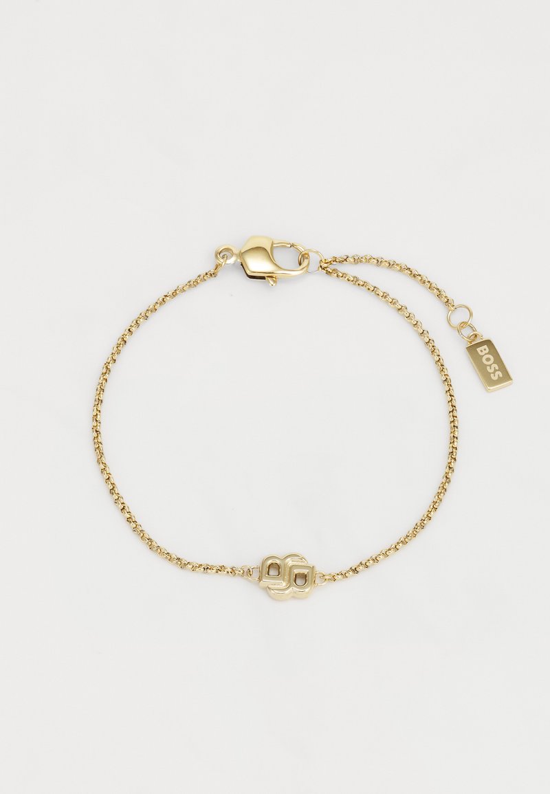 Bracciale in oro con un design minimalista, dotato di un ciondolo geometrico e di una chiusura a gancio. Include una piccola targhetta incisa con la scritta "BOSS."