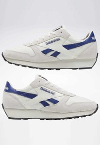 Reebok-sneakers med en vit och blå färgkombination, med en blandning av mocka och syntetiska material, texturerade snören och svarta gummisålar.