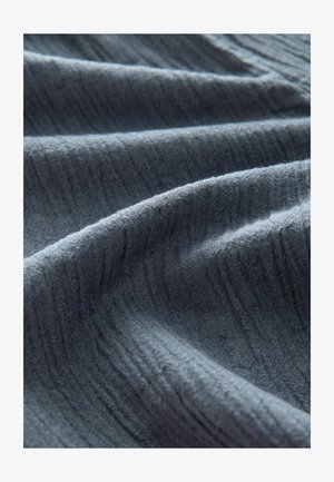 Textured dark gray fabric with rippled folds, showcasing a soft and slightly uneven surface, emphasizing woven material and color depth.