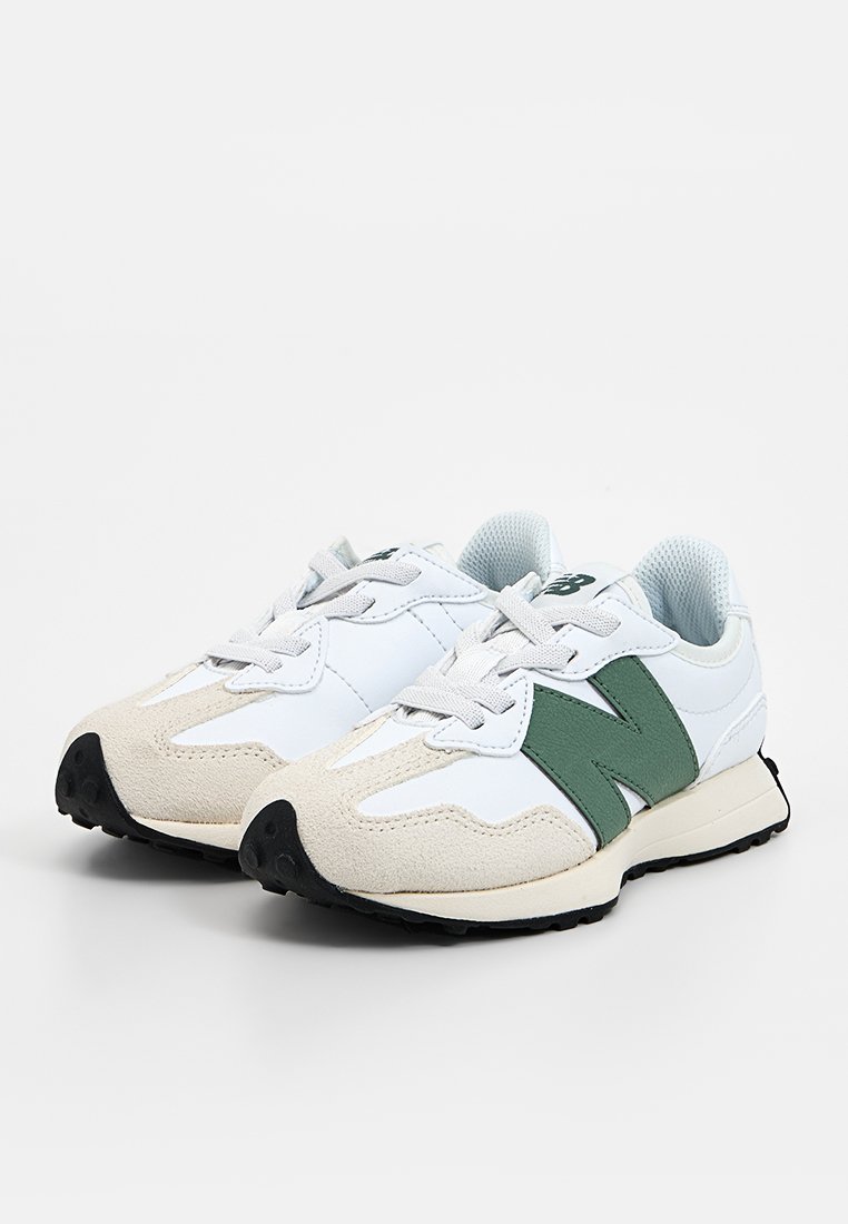 Baskets blanches de sport avec des accents verts, dessus en daim et synthétique, design à lacets, semelle extérieure texturée et un logo 'N' prominent.