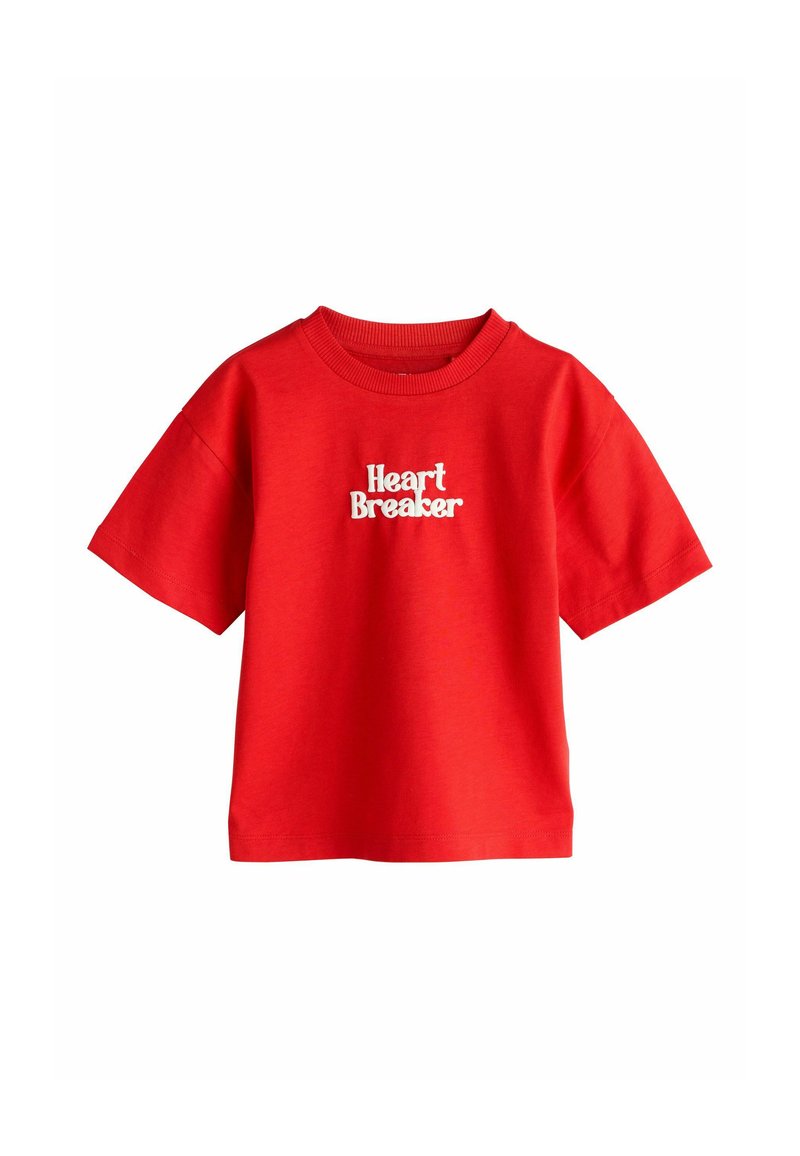 Punane puuvillane lühikeste varrukatega t-särk, mille rinnal on valge "Heart Breaker" graafika julge ja mängulise kirjatüübiga. Lõõgastunud istuvus.